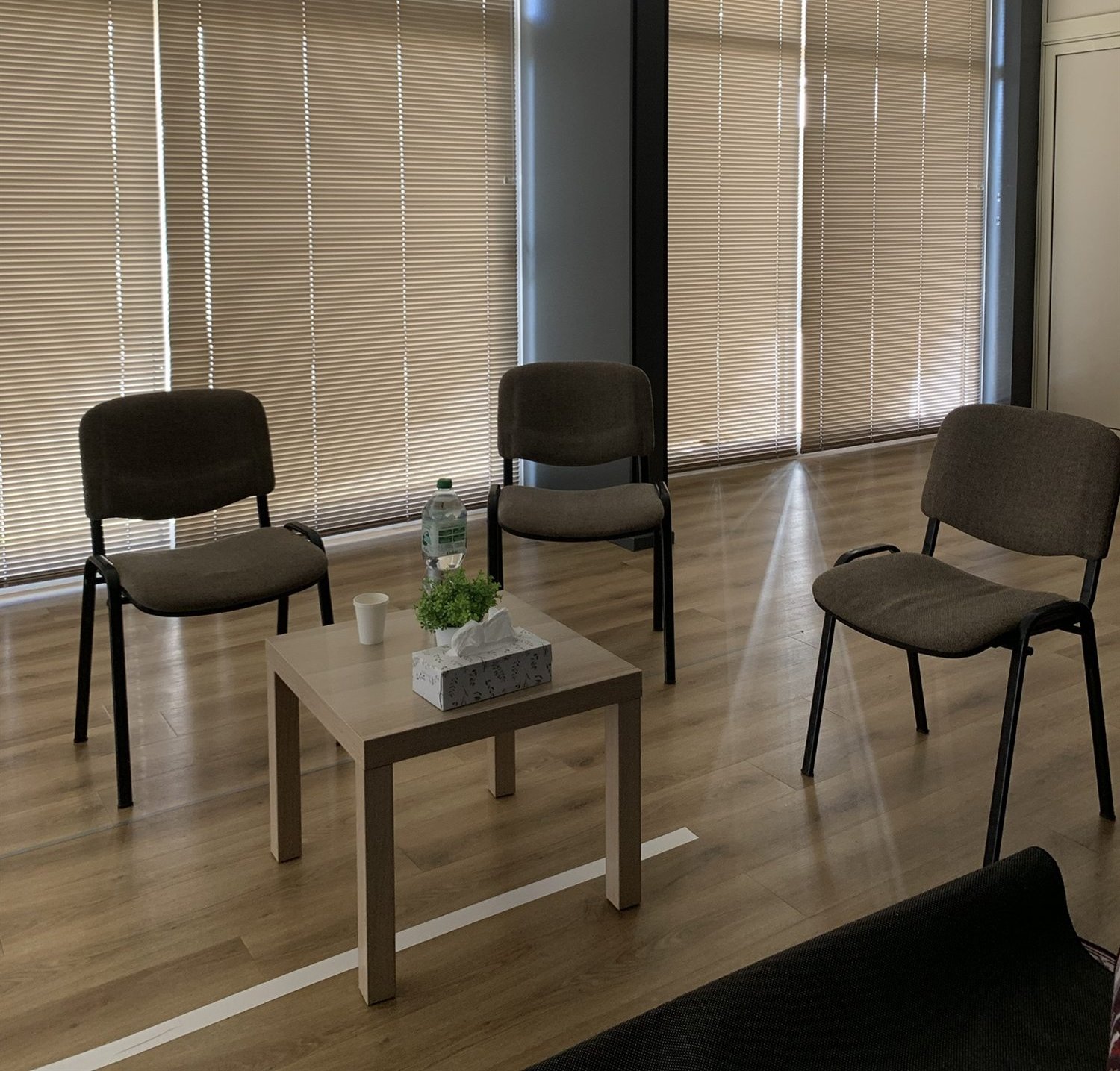 Tafeltje met plantje en water op een kleed in de zaal